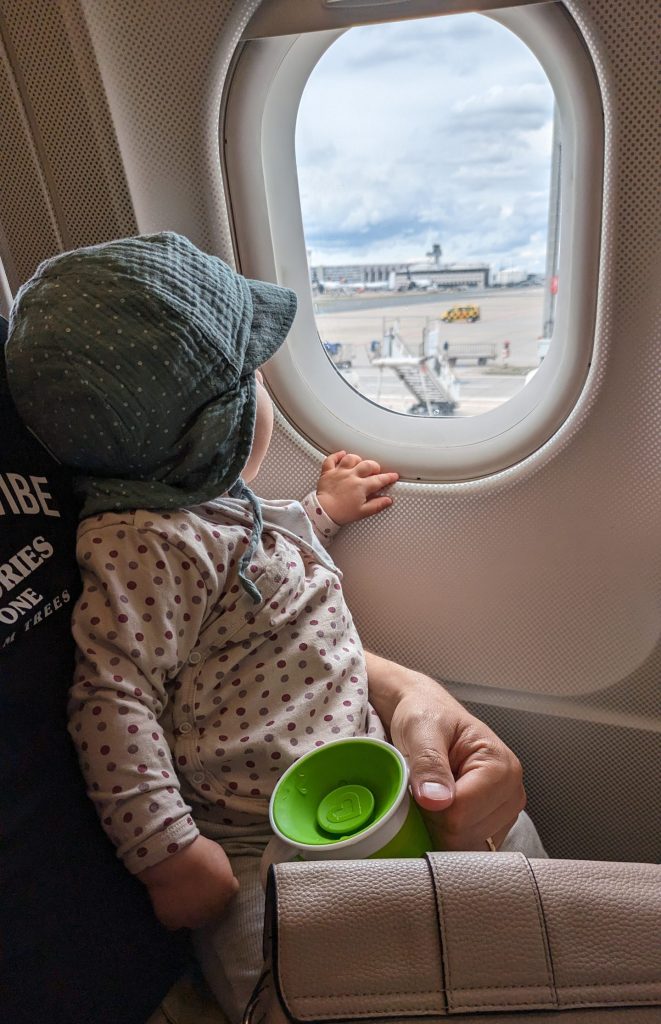 Baby sitzt im Flugzeug auf dem Schoß