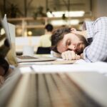 Wiedereinstieg ins Berufsleben, harte Nacht mit Kind oder Baby. Vater müde bei der Arbeit